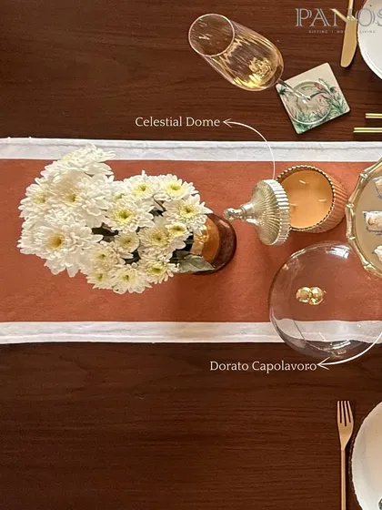 A detail from our Ganesh Chaturthi setup, featuring our Celestial Dome candle and Dorato Capolavoro glass cloche. These pieces add layers of golden hues and warm light to your festive table.