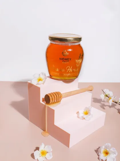 A minimalist and elegant shot using geometric props. The steps create a pedestal for the honey jar, giving it a premium and aspirational look.