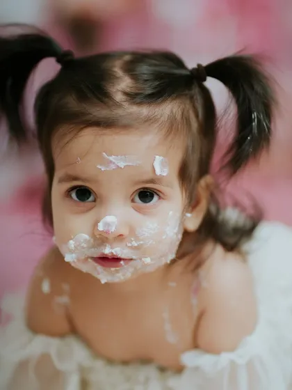 It's all in the details. From the pigtails to the frosting on her nose, this close-up from a cake smash session captures the sweet, messy reality of being one year old.