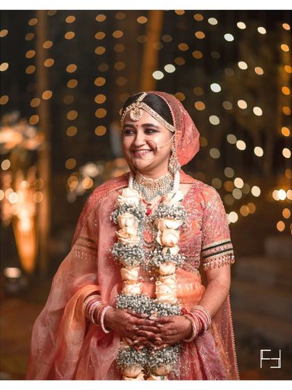 A candid portrait of Nidhi, capturing a natural, unposed smile. These are the moments that truly reflect the bride's happiness on her special day.