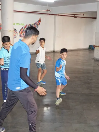 Young boys learning the basic 'en garde' position during a summer camp session. We break down the sport into simple, easy-to-learn steps.