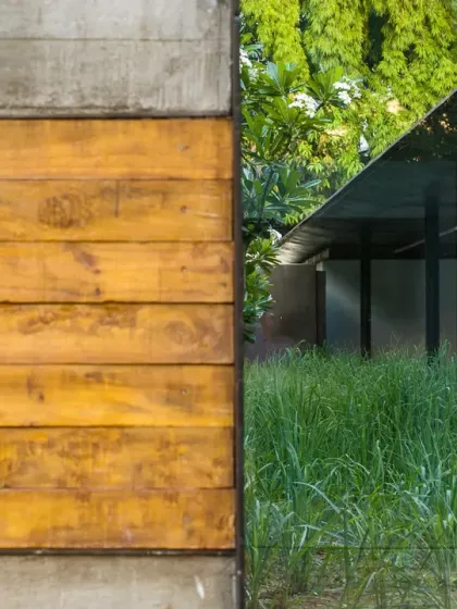 A detail at the ATE Pune facility, where a concrete wall inlaid with wood meets a field of wild grass. This juxtaposition of refined and raw materials is a hallmark of my approach to adaptive reuse.