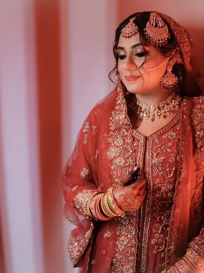 Professional photos of my bride Uzma for her Nikah reception. The warm lighting enhances the rich red of her outfit and the golden tones in her makeup.