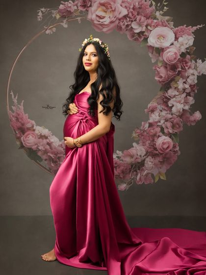 An elegant portrait of a mother-to-be framed by a beautiful floral hoop. The rich color of the gown and the soft floral elements create a perfect balance.