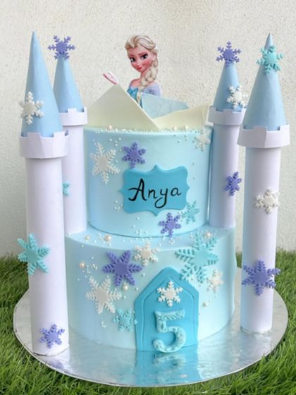 Let it go! This Frozen castle cake is a dream for any little princess. The two-tiered design is frosted in icy blue whipped cream and features a grand castle with towers made of fondant and white chocolate.