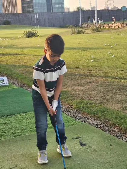 A young boy focuses on his stance and grip during a practice session. Our programs are designed to be engaging and fun for our junior golfers.
