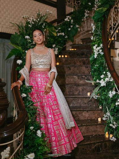 The bride posing on a beautifully decorated staircase. Her radiant makeup catches the light, and the simple, natural style ensures she feels comfortable and like herself.