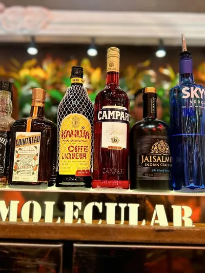A full lineup of our premium offerings, including Johnnie Walker Black Label, Cointreau, Kahlua, and Jaisalmer Gin. The illuminated "Luxury Molecular Bar" sign reinforces our commitment to quality.