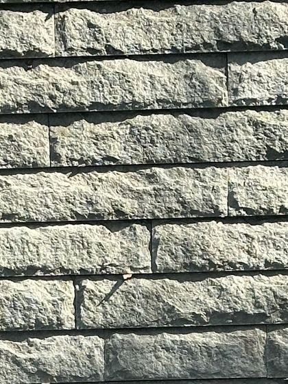 A close-up of the hand-chiseled stone texture. Each mark is a record of the force and intention required to shape the material.