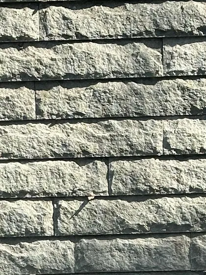 A close-up of the hand-chiseled stone texture. Each mark is a record of the force and intention required to shape the material.
