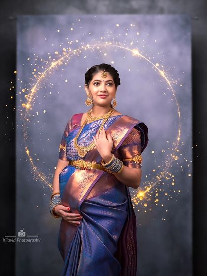 A beautiful portrait in a blue silk saree, enhanced with a magical golden halo effect to celebrate the divine glow of motherhood.