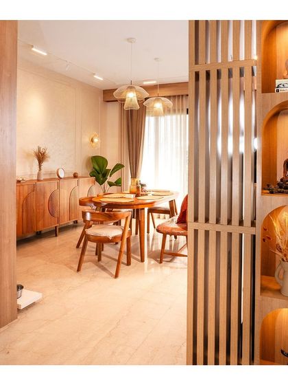 A view from the foyer into the dining area, showing a slatted wood partition with built-in niches for displaying art and artifacts, a hallmark of our custom work.