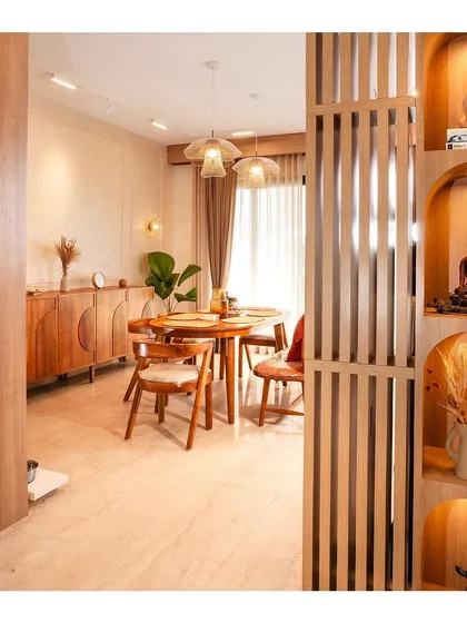 A view from the foyer into the dining area, showing a slatted wood partition with built-in niches for displaying art and artifacts, a hallmark of our custom work.