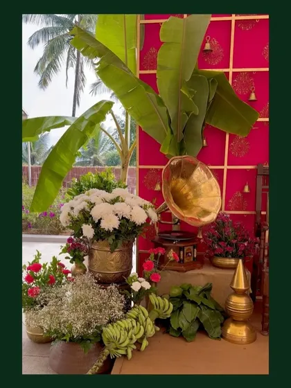 A traditional decor corner featuring a brass gramophone, banana leaves, and fresh flowers, blending natural and vintage elements perfectly.