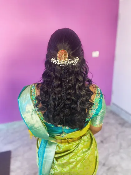 The back view of the half-updo, showing the beautiful hair accessory and the flow of the curls.