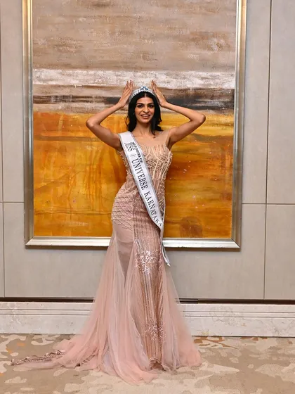 A moment of pure joy and achievement. The makeup is designed to look flawless from every angle, highlighting her features and creating a radiant glow that matches the crown.