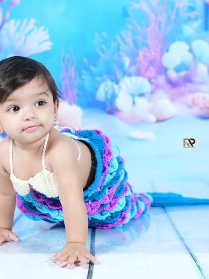 A crawling baby mermaid explores her magical surroundings. The detailed and colorful backdrop brings this underwater fantasy to life.