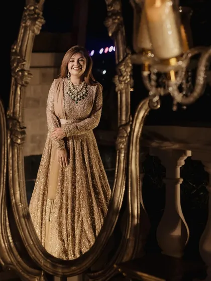 A stunning reflection. This artistic shot showcases the bride's complete look, from her elegant gown to her polished makeup.