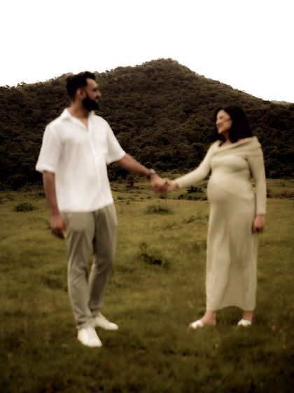 A simple, classic pose of the couple holding hands in a field, facing each other with a smile. It’s a timeless representation of their partnership.