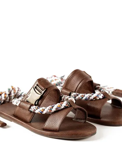 A pair of brown leather sandals with unique rope ties from Jeetinder Sandhu. This shot captures the artisanal and bohemian feel of the design.