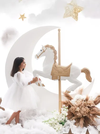 Riding a carousel to the moon. This whimsical theme combines a classic carousel horse with a dreamy moon and stars backdrop. It's a magical setting that sparks the imagination.