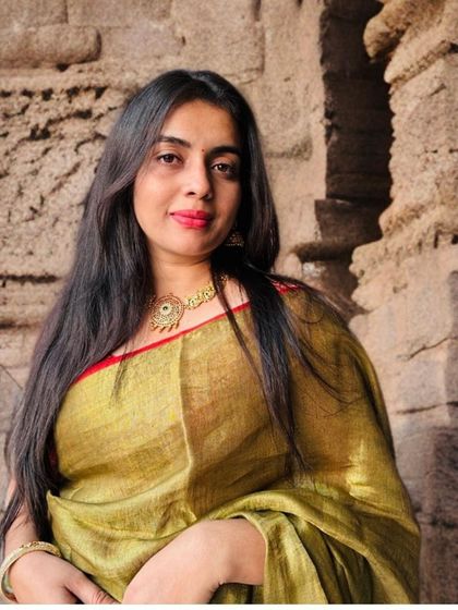 Another shot of the copper tissue saree, this time against a rustic backdrop that highlights its earthy, warm tones.