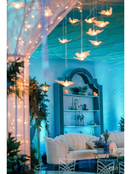 Another view of the lounge area, showing how the lighting and decor work together to create a serene, underwater ambiance. The hanging lights resemble glowing jellyfish or air bubbles.