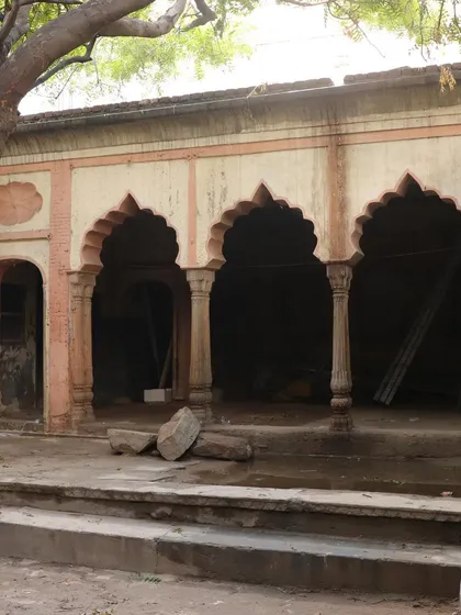The arched verandah before restoration, with rubble and decay masking the beautiful architectural forms.