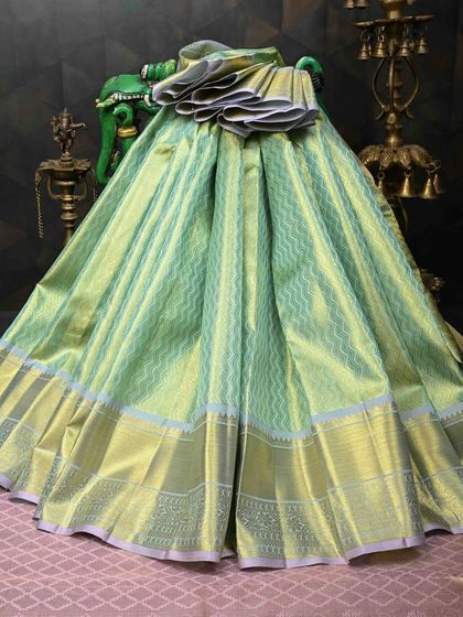 A pastel green Kanjivaram silk saree with a subtle chevron weave and a silver border. This is a sophisticated and modern take on the classic Kanjivaram.