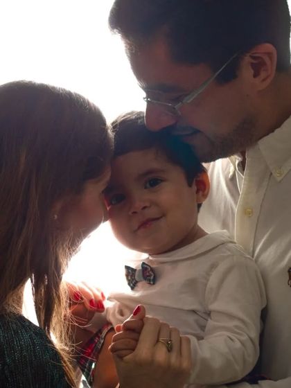 A soft and tender backlit family moment. The bright light envelops the family, creating a warm, angelic, and emotional portrait.