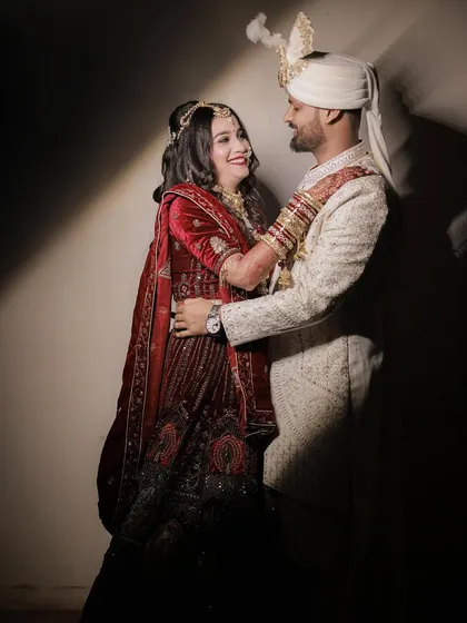 A candid and joyful moment between the couple. They are captured in a happy embrace, laughing and looking at each other, showcasing the genuine fun and love they share.