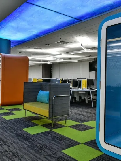 A collection of phone booths and small breakout seating areas in an open-plan office. The different colors and shapes add visual interest and provide a variety of options for employees.