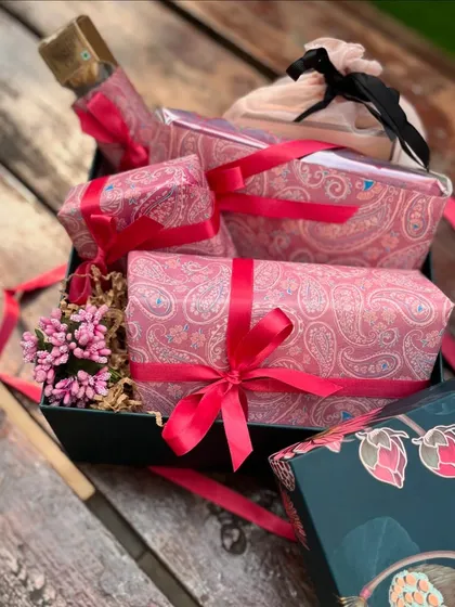 A look inside the 50th birthday box, where each item is meticulously wrapped in paisley paper and tied with vibrant ribbons, creating a joyful unboxing experience.