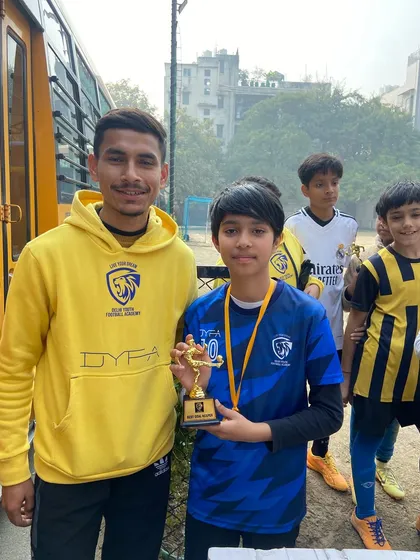 A player beaming with pride, holding his trophy. These moments build confidence and a love for the game.
