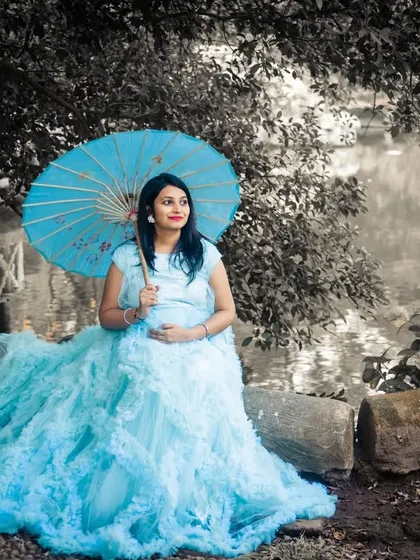 A color-splash effect highlights the mom-to-be in her light blue ruffled gown, creating an artistic and eye-catching portrait.