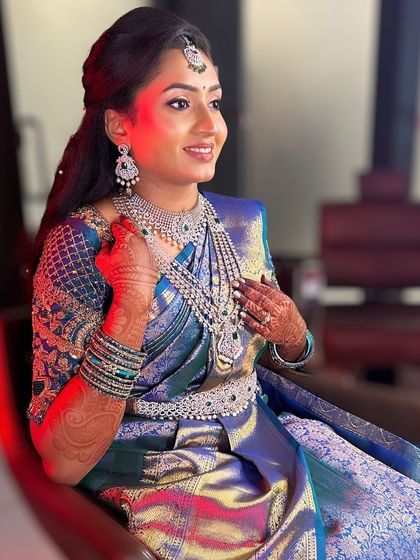 A smiling shot of Amulya. The full CZ set, including the choker, long haram, and vaddanam, sparkles beautifully, making her look like a star.