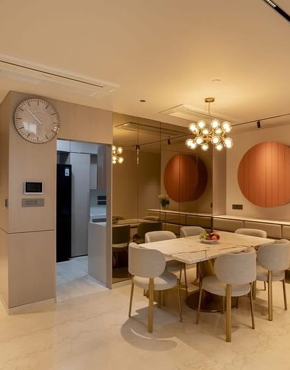This is a dining space I designed for a project at Oberoi Sky City. The room is defined by modern minimalism, with a marble-top table, sleek chairs, and a unique circular art piece that conceals a bar cabinet.
