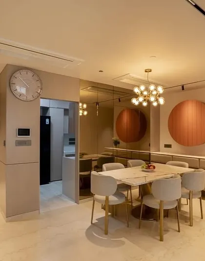 The dining area of a modern apartment I designed at Oberoi Sky City. The space is defined by a marble-top table, contemporary chairs, and a unique circular wall cabinet that doubles as art.