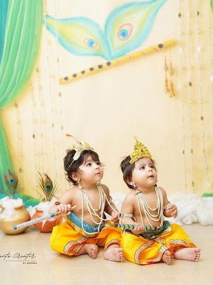 A curious glance from our twin Krishnas. Their coordinated outfits and the beautifully decorated set create a stunning visual story.
