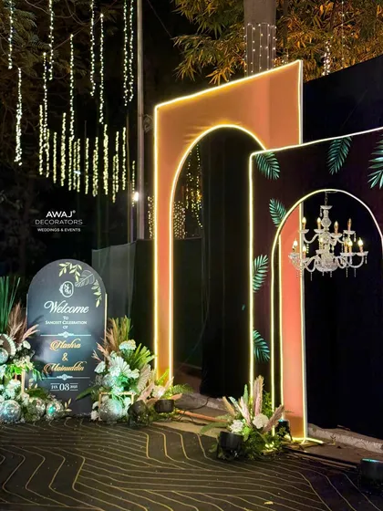 The welcome area for the Sangeet, featuring a custom sign and floral arrangements that match the modern, tropical theme.