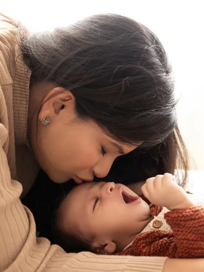 A sleepy yawn from the baby as his mother kisses his forehead. I love capturing these real, unscripted moments.