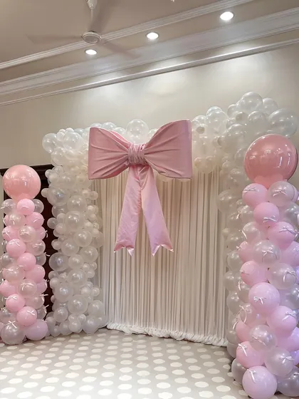 Another angle of the pink bow balloon arch, showing the full structure. It's a sweet and classic choice for welcoming a new baby girl.