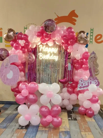 A full view of our Barbie-themed birthday setup. The pink and white balloon arch, Barbie cutouts, and shimmering backdrop create a glamorous photo spot.