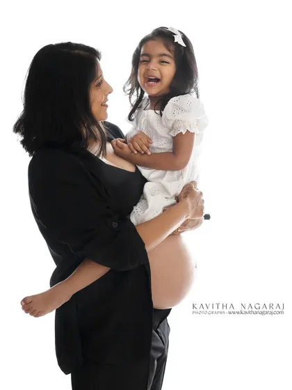 A candid moment of pure joy as a mother-to-be laughs with her daughter. These unscripted moments are often the most treasured from a maternity session.