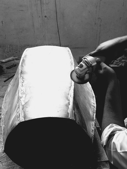 The raw form of a custom table base being meticulously finished by hand. This level of craftsmanship ensures that every piece of bespoke furniture is a work of art.