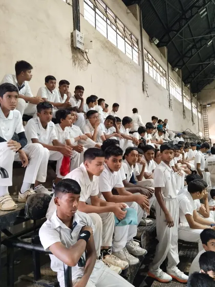 Young players watching intently from the stands, learning from others while they await their turn.