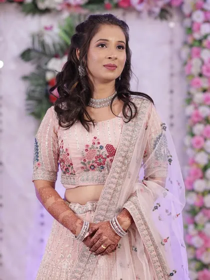 A soft and pretty look in a pastel pink lehenga. The makeup is fresh and youthful, perfect for a sangeet or reception.