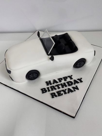 A top-down view of the white convertible cake, showing the detailed interior seats.