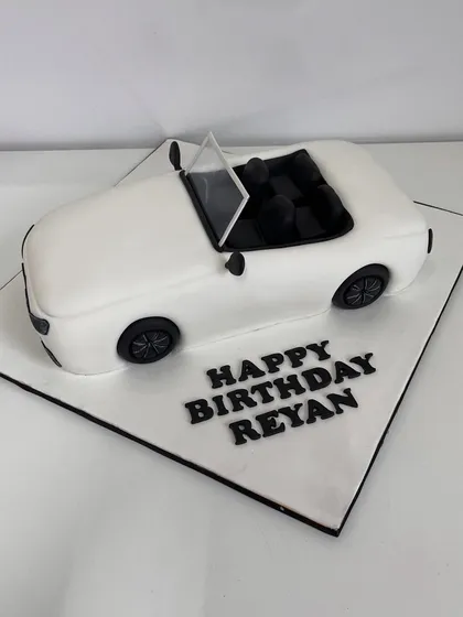 A top-down view of the white convertible cake, showing the detailed interior seats.