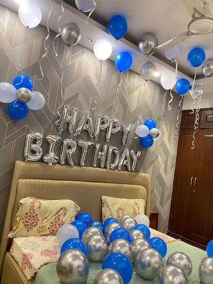 A closer look at the "Happy Birthday" foil balloon banner, which serves as the centerpiece for this bedroom surprise.